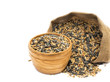 Mixed bird seeds for winter feeding in a sack and wooden bowl on white background 