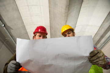 Two construction worke or architects, constructing and checking development of a small business hall. Reliable civil engineer working on a construction site, foreman at work