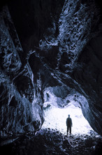 Caving Adventure. Man At Cave Entrance Exploring The Dark Underground Tunnel