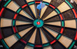 © HappyLenses - Blue dart in the center of a colorful dartboard target