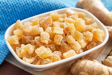 Wall Mural - Candied ginger in white bowl on wooden background