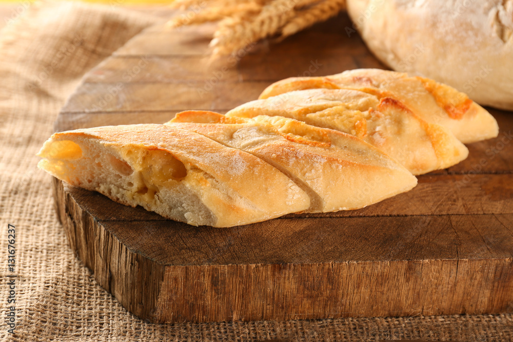 Sliced baguette on wooden cutting board closeup