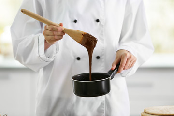 Cooking concept. Professional confectioner making chocolate frosting