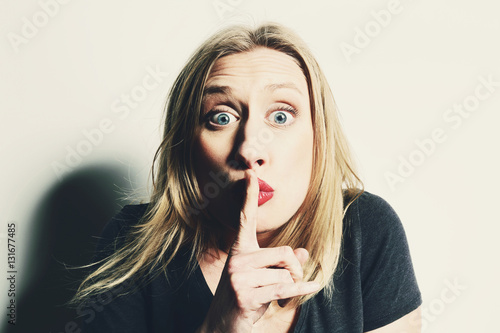 Femme Drôle Blonde Demandant Le Silence Avec Une Grimace