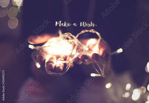 Fotografering Make a wish word over hand with light bokeh in vintage filter,Ho