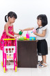 Leinwandbild Motiv Asian Chinese little sisters pretending customer and cashier wit