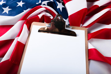 blank clip board and USA flag on wooden background