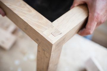 Detail of a furniture maker holding an example of his intricate