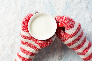 Sticker - female hands in gloves holding hot cup of milk