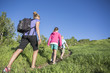 © Brocreative - Family Hiking together in the mountains on a clear summer day. Children walking in front of mother along a path. Mother wearing a backpack