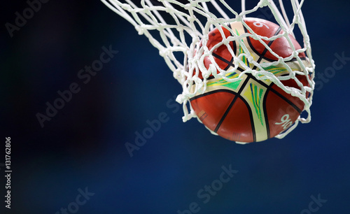 Plakat Piłka do koszykówki przechodzi przez kosz, sieć