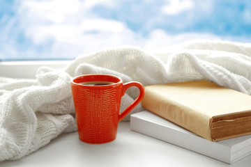 Poster - Cup of fresh coffee with books and knitted plaid on windowsill