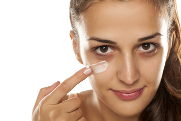 young beautiful woman applied protective cream on her face