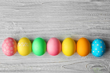 Wall Mural - Colorful Easter eggs on wooden table