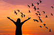     silhouette woman standing raised up hands celebrate during  flock of lesser whistling duck flying on sunset
