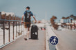 © skyNext - Blurred silhouette of a man with huge luggage bag going over narrow special pathway on sunny summer day with clear sky in Barcelona, special Icon means path for people with luggage