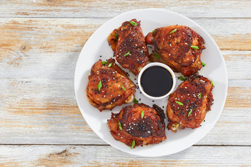 Wall Mural - grilled chicken thigh on white plate sprinkled with sesame seeds