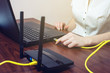 © Artem - woman connect Internet cable to connector on the laptop