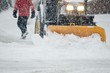 Person Walking Through Snow Storm with Plow Plowing Street