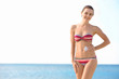 © Africa Studio - Young woman applying sun protective lotion on body at the beach