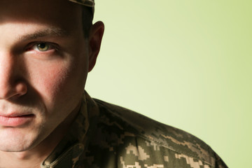 Wall Mural - Soldier in camouflage on grey background, closeup