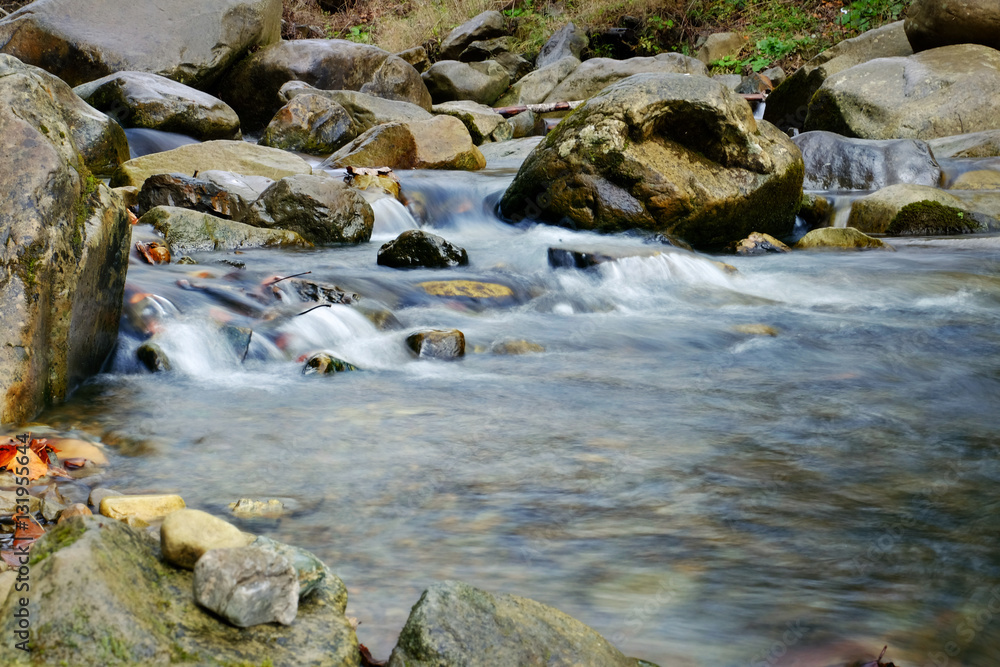 Stream flowing through rocky path in mountains