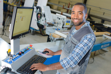 man typing at factory computer