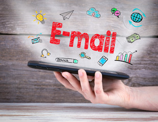 Wall Mural - E-mail concept. Tablet computer in the hand. Old wooden background.