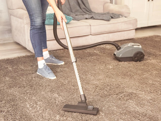 Wall Mural - Cleaner hoovering carpet in room