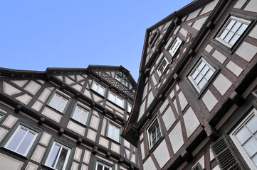 Wall Mural - Look up at two old typical half-timbered houses of black frame and white stucco. Waiblingen, Baden-Wurttemberg, Germany.