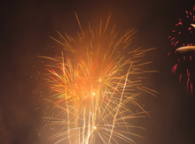 Several Bright Explosions Of Orange And Yellow Fireworks
