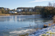 © Martin Henke - Winterlandschaft: Zugefrorener See mit Reflektionen und Textfreiraum vor moderner Architektur