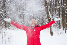 Portrait Of A Nice Senior Woman In The Winter Snow Wood In Red Coat