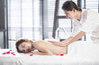 © Blue Jean Images - Masseuse giving a back massage to a woman in a spa