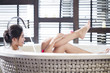 © Blue Jean Images - Beautiful young woman in bathtub with rose petals