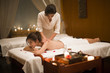 © Blue Jean Images - Masseuse giving a back massage to a woman in a spa