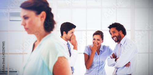 Fotografía Colleagues gossiping with sad businesswoman in foreground