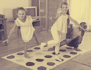 Wall Mural - Children playing twister at home.