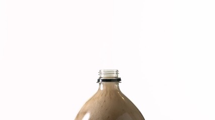 Soda bottle exploding soda on white background.