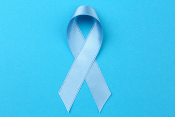 Wall Mural - Light blue ribbon on color background. Prostate cancer concept