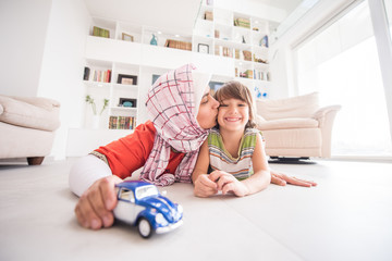 Mother and cute son playing with car toy at living room