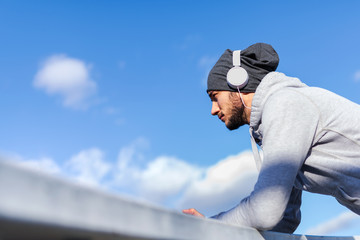 A young athlete man with headphones resting listening music