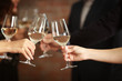© Africa Studio - Female hands toasting with glasses of white wine, closeup