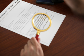 Wall Mural - Notary public reading power of attorney through magnifier