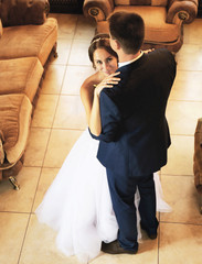 Wall Mural - Beautiful bride and groom dancing in room