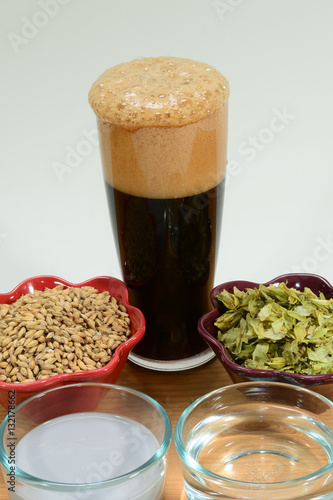Fotografia, Obraz Home Brew Beer ingredients shown with a glass of foamy beer with malted barley g
