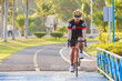 © jayzynism - Man riding mountain bike on bridge trail at sunrise at public pa