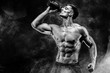 © ZaStock - Muscular man with protein drink in shaker over dark smoke background