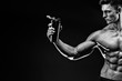 © ZaStock - Muscular man with protein drink in shaker over dark background