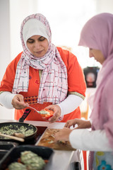 Muslim Arabic traditional woman in kitchen preparing food for lu